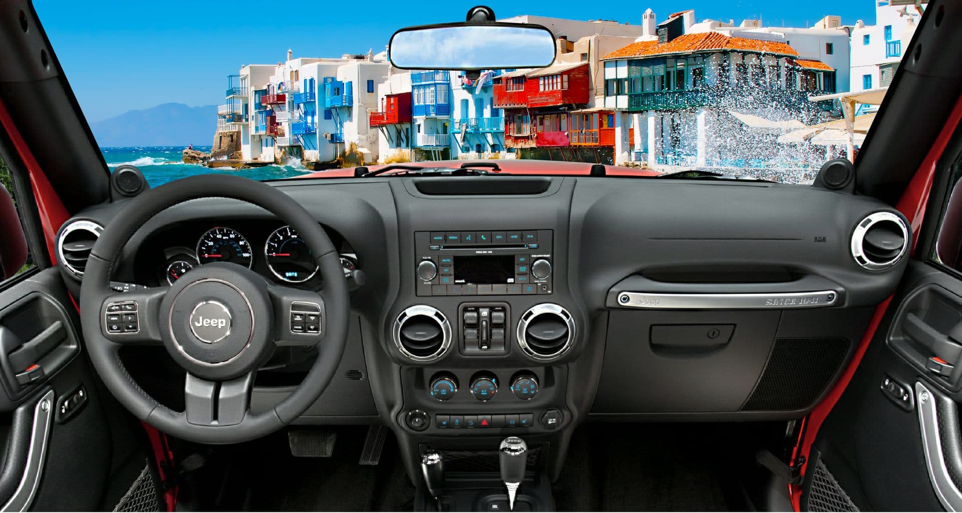 View from behind the wheel of a Jeep, looking out at Little Venice, Mykonos